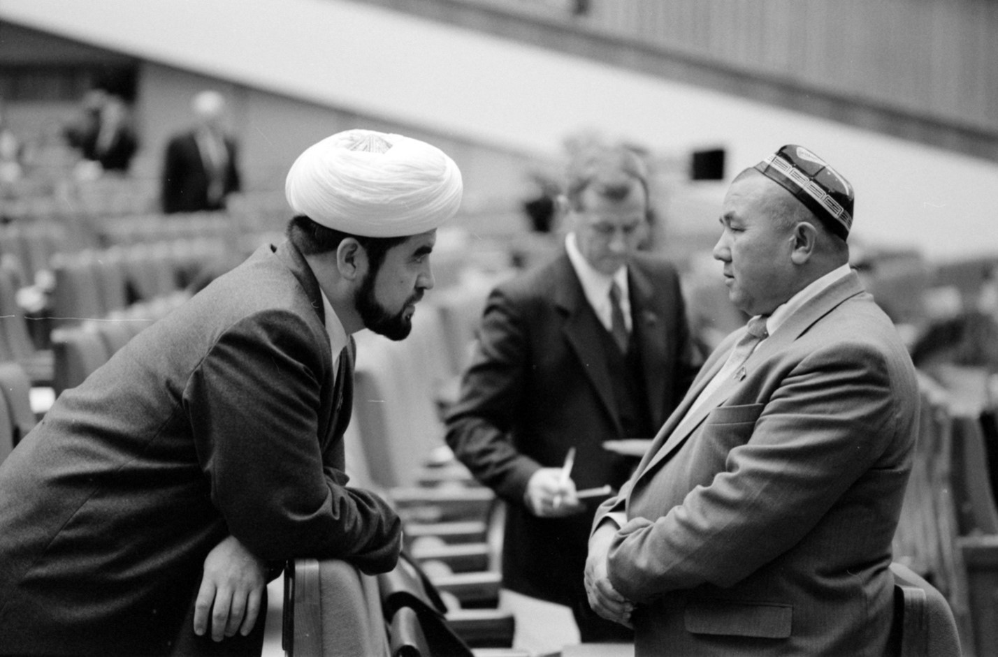 Figure 2: Deputies of the Third (Extraordinary) Congress of People’s Deputies of the USSR Mukhammad-Iusuf Mukhammad-Sodik, Chairman of the Spiritual Board of the Muslims of Central Asia and Kazakhstan, and Mamatgazi Shergaziev, Сhairman of the Collective Farm “Leningrad” of the Fergana Region of Uzbekistan, talking during a break between sessions. Moscow, March 13, 1990. From the collection of the RGAKFD, Krasnogorsk, Item 0-355521.